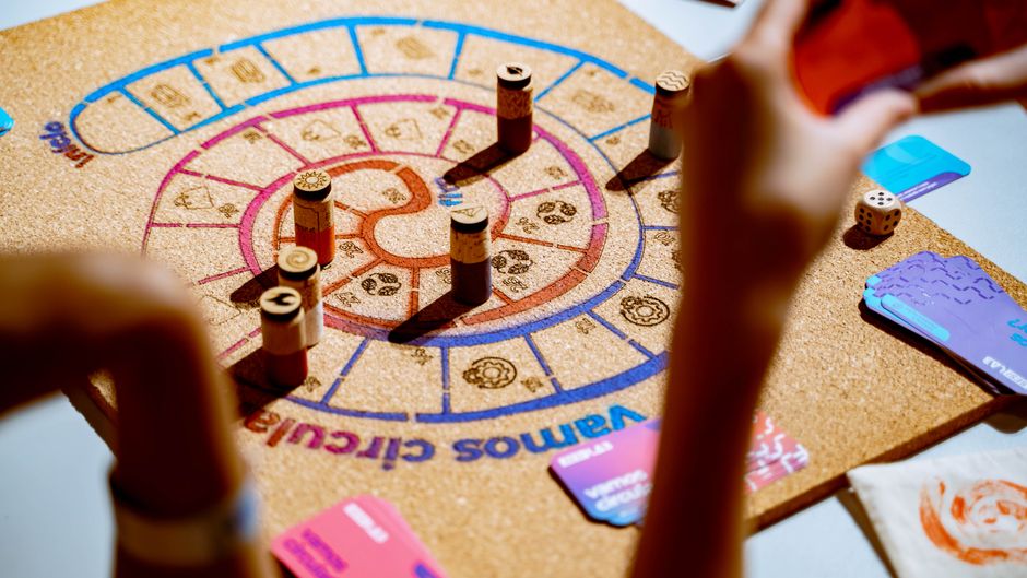 Jogo de estratégia com peças e cartas coloridas sobre a mesa