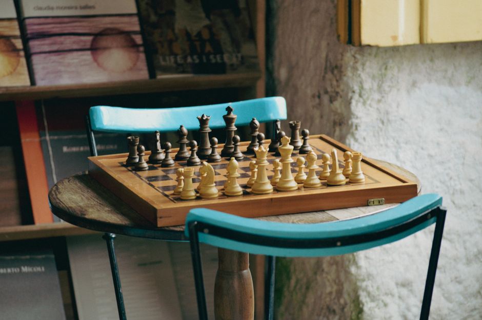 Tabuleiro de xadrez de madeira preparado numa mesa rústica