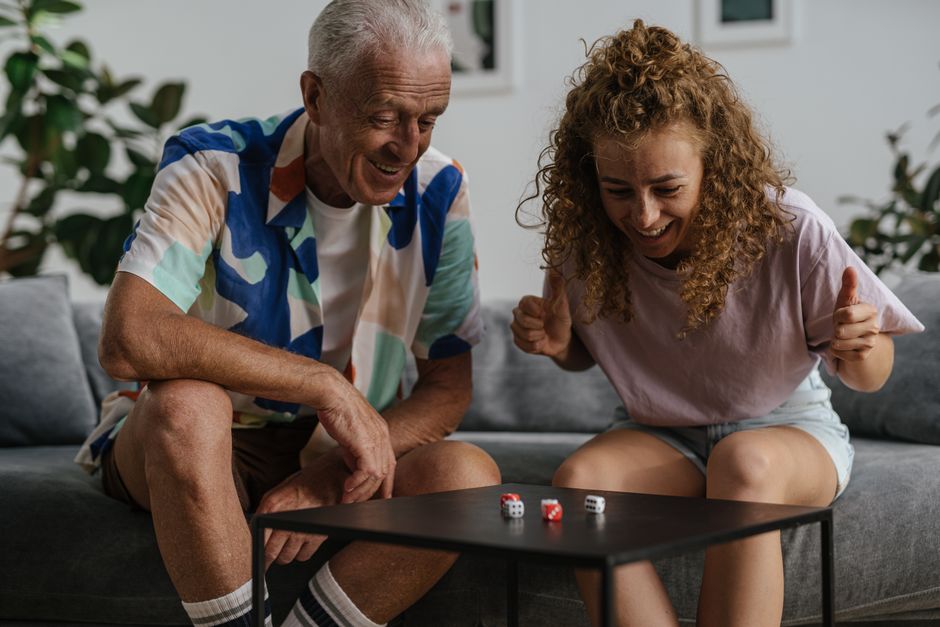 Homem mais velho e mulher jovem a jogar com dados