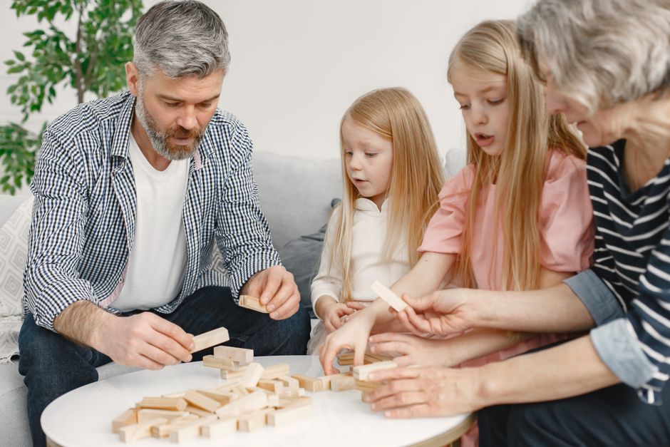 Quatro membros de uma família a brincar com blocos na mesa